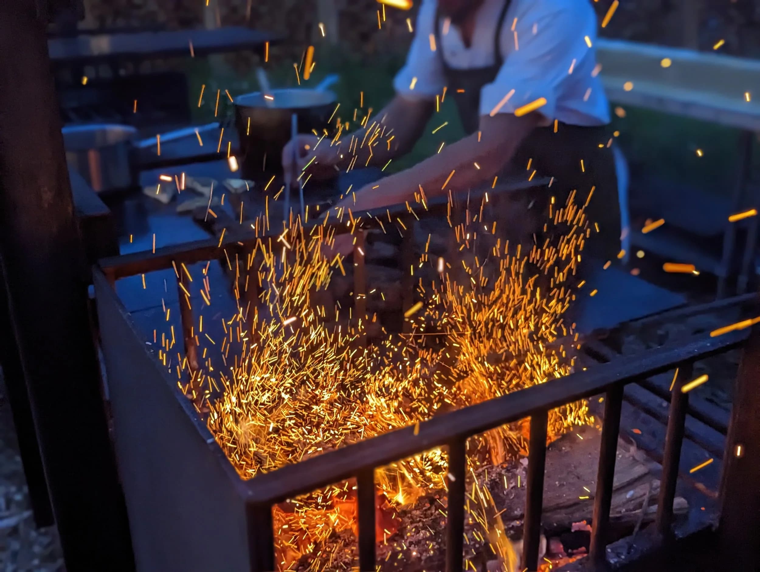 Sparks flying from the open-fire grill at a Celeste Farms dinner