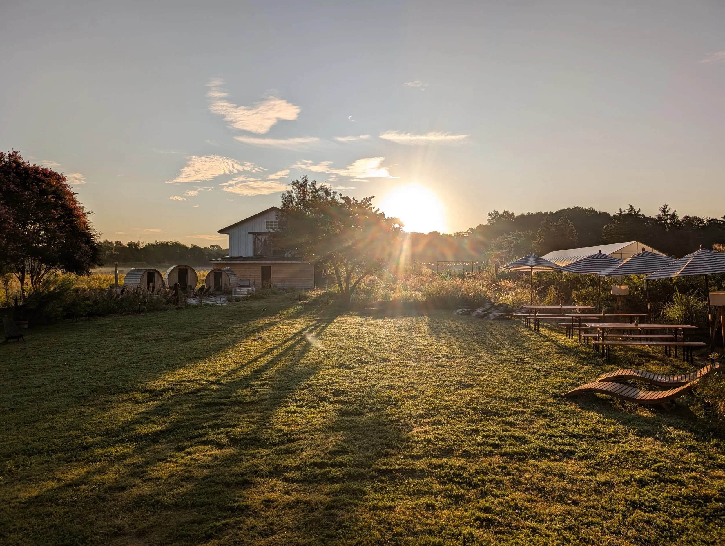 Sunrise over Celeste Farms with sauna barrels and long tables