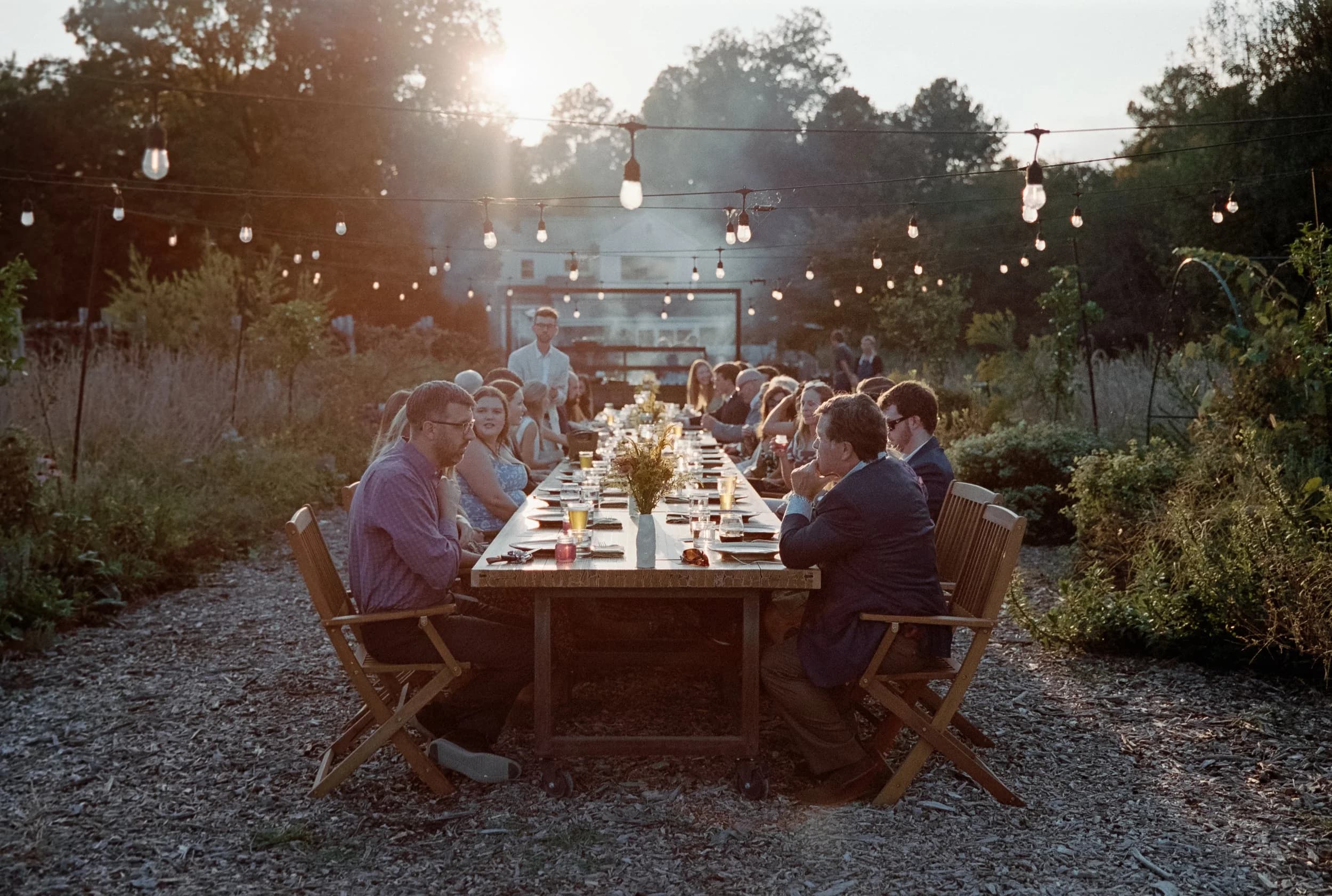 Long dinner table under string lights at Celeste Farms