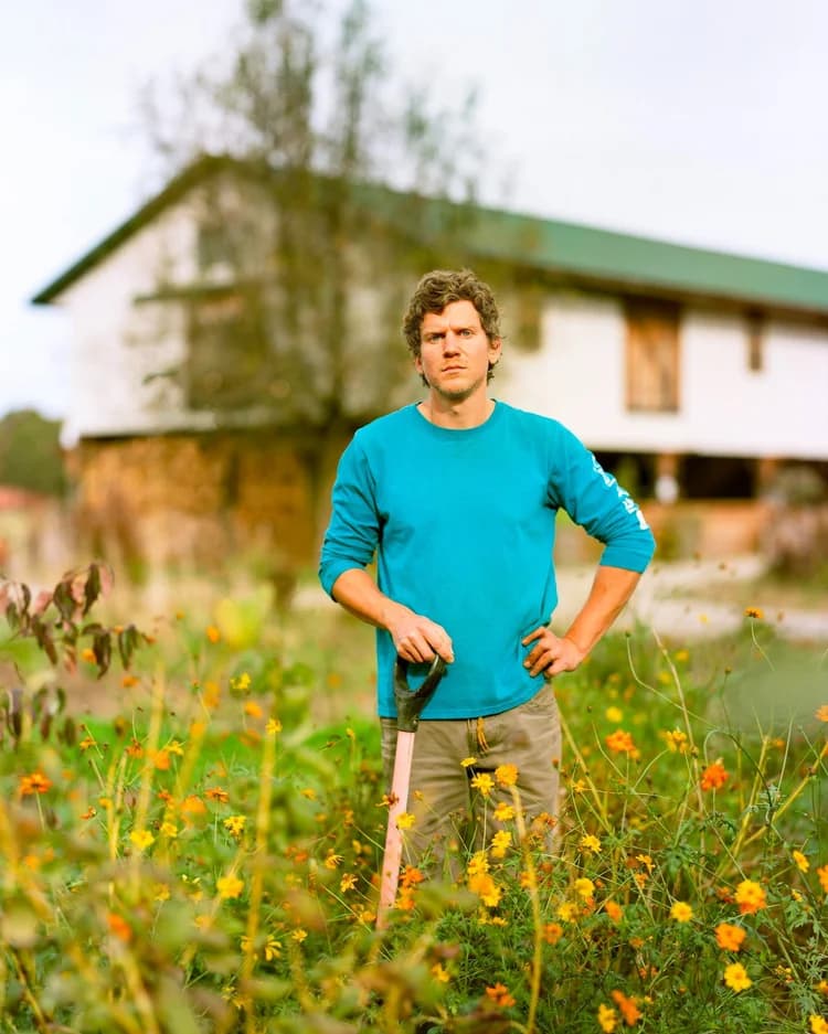 Michael standing in a wildflower field in front of the farmhouse