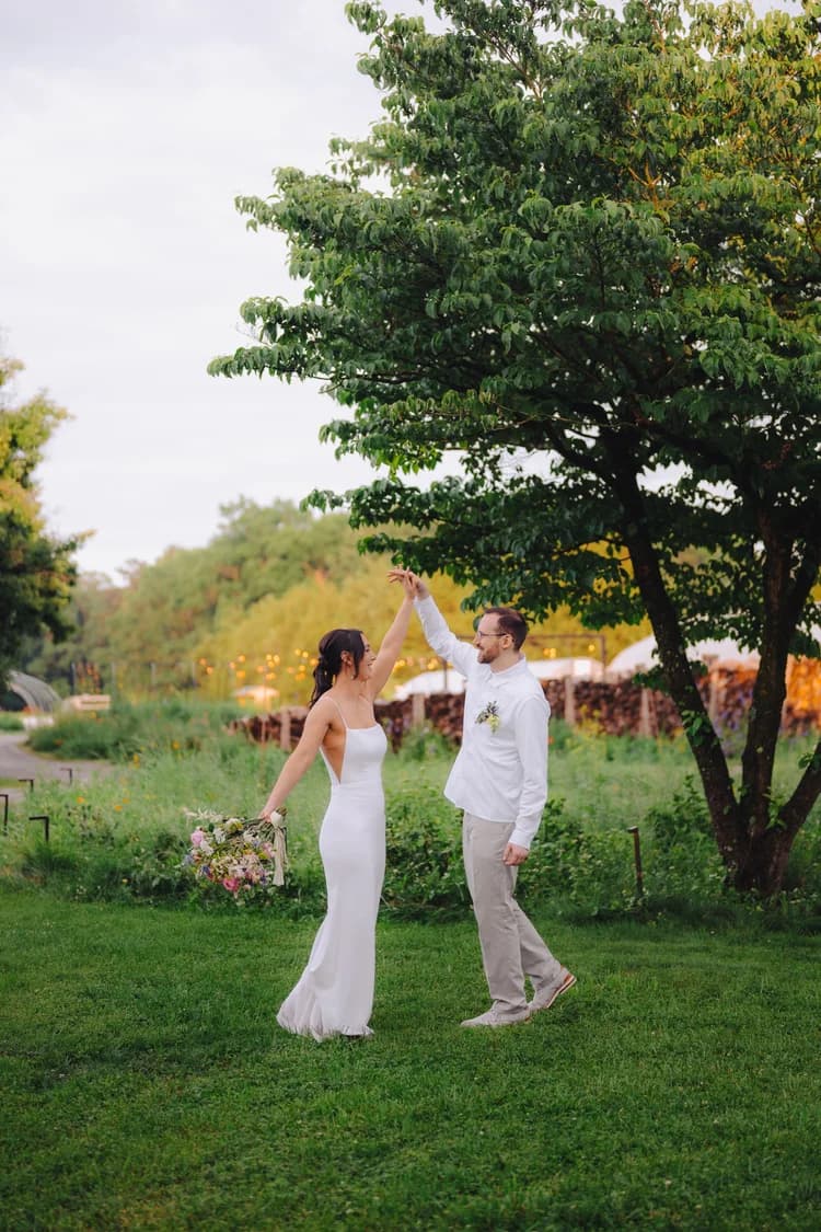 Bride and groom dancing under a tree at golden hour