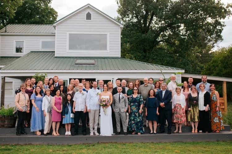 Wedding family group portrait in front of the farmhouse